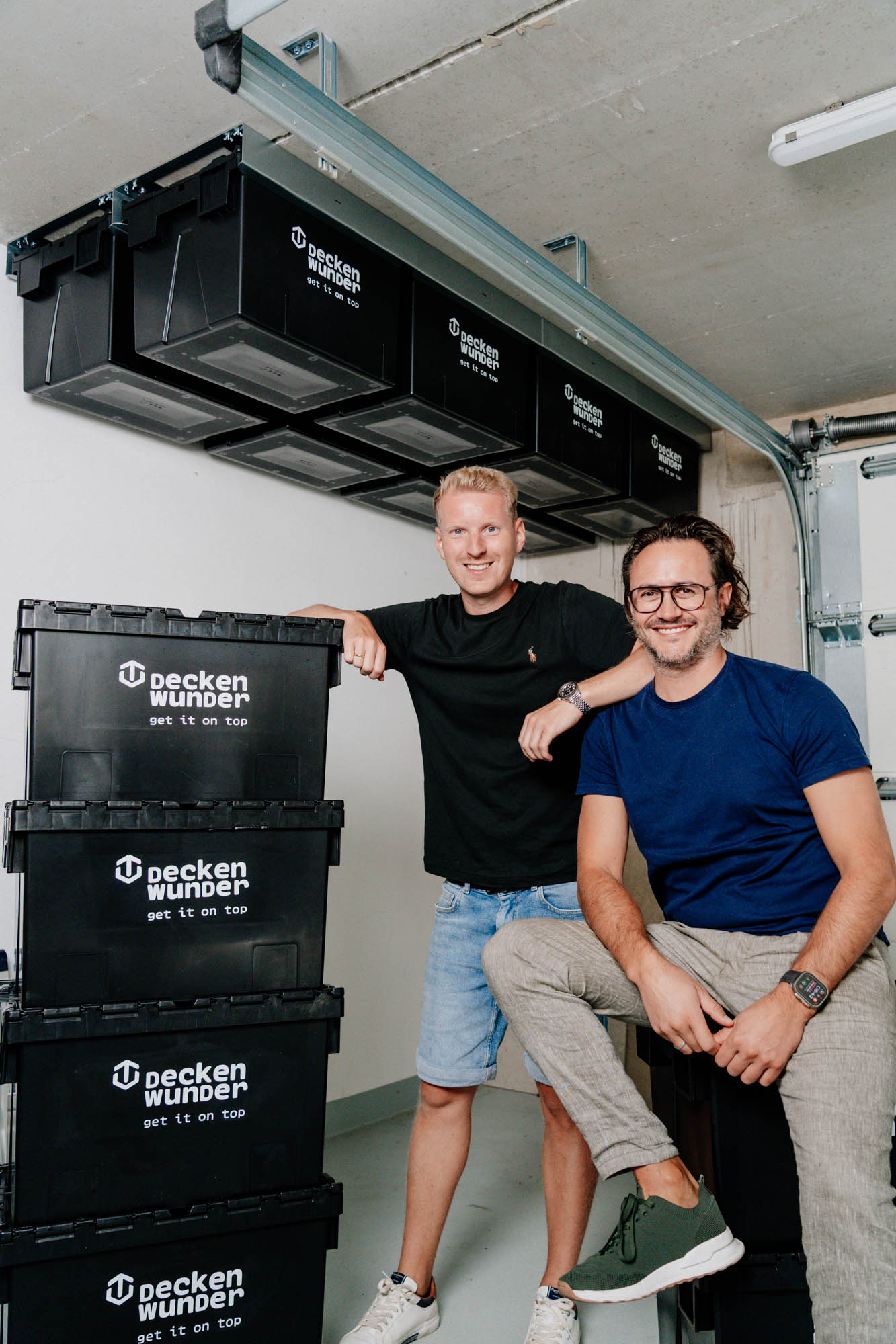 Das Deckenwunder-Team mit Deckenwunder-Aufbewahrungsboxen in einer Garage